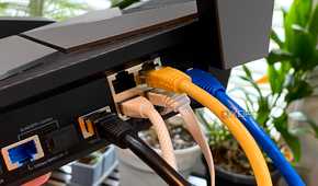 Ethernet cables of various types plugged into a TP-Link Archer AXE300