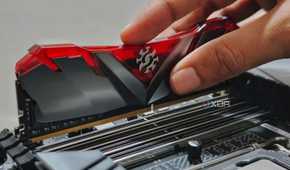 An image showing a person installing RAM modules on a motherboard.