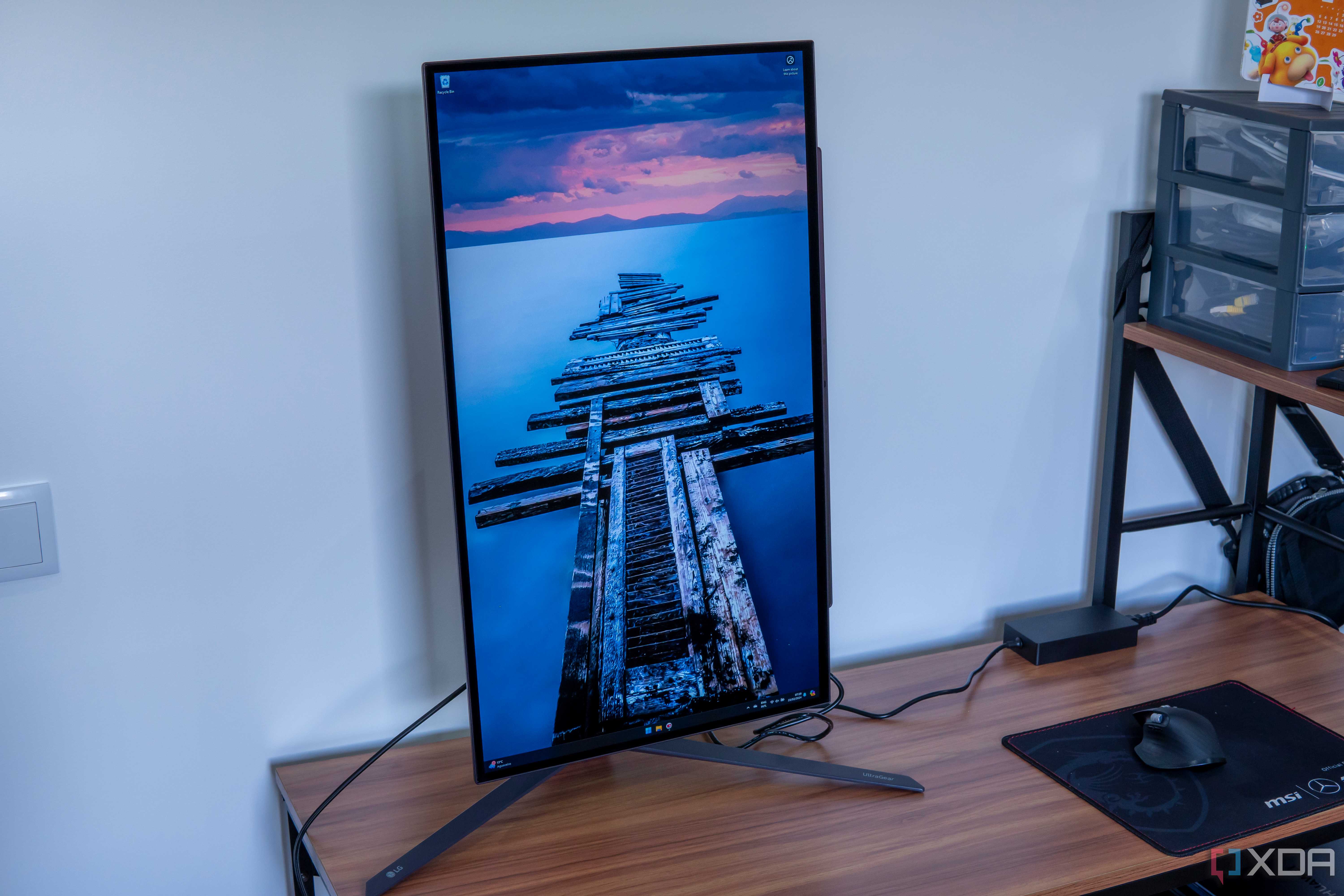 Angled front view of the LG UltraGear 27GR95QE with the screen in portrait orientation