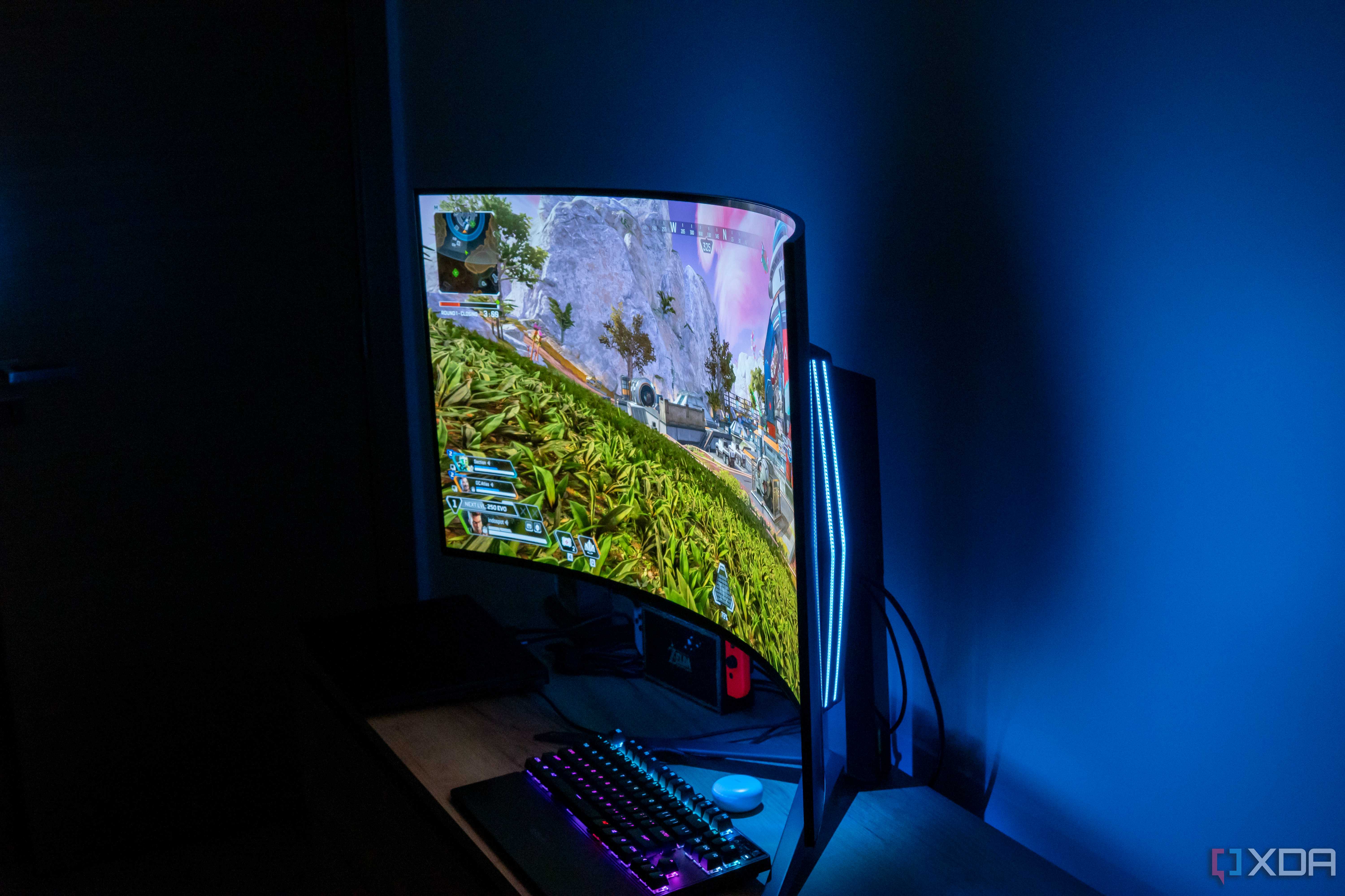Angled view of the LG UltraGear 45GR95QE in a dark room playing Apex Legends with RGB lighting in the back