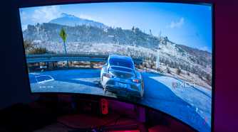 Angled view of the LG UltraGear 45GR95QE in a dark room with Forza Horizon 5 on the screen
