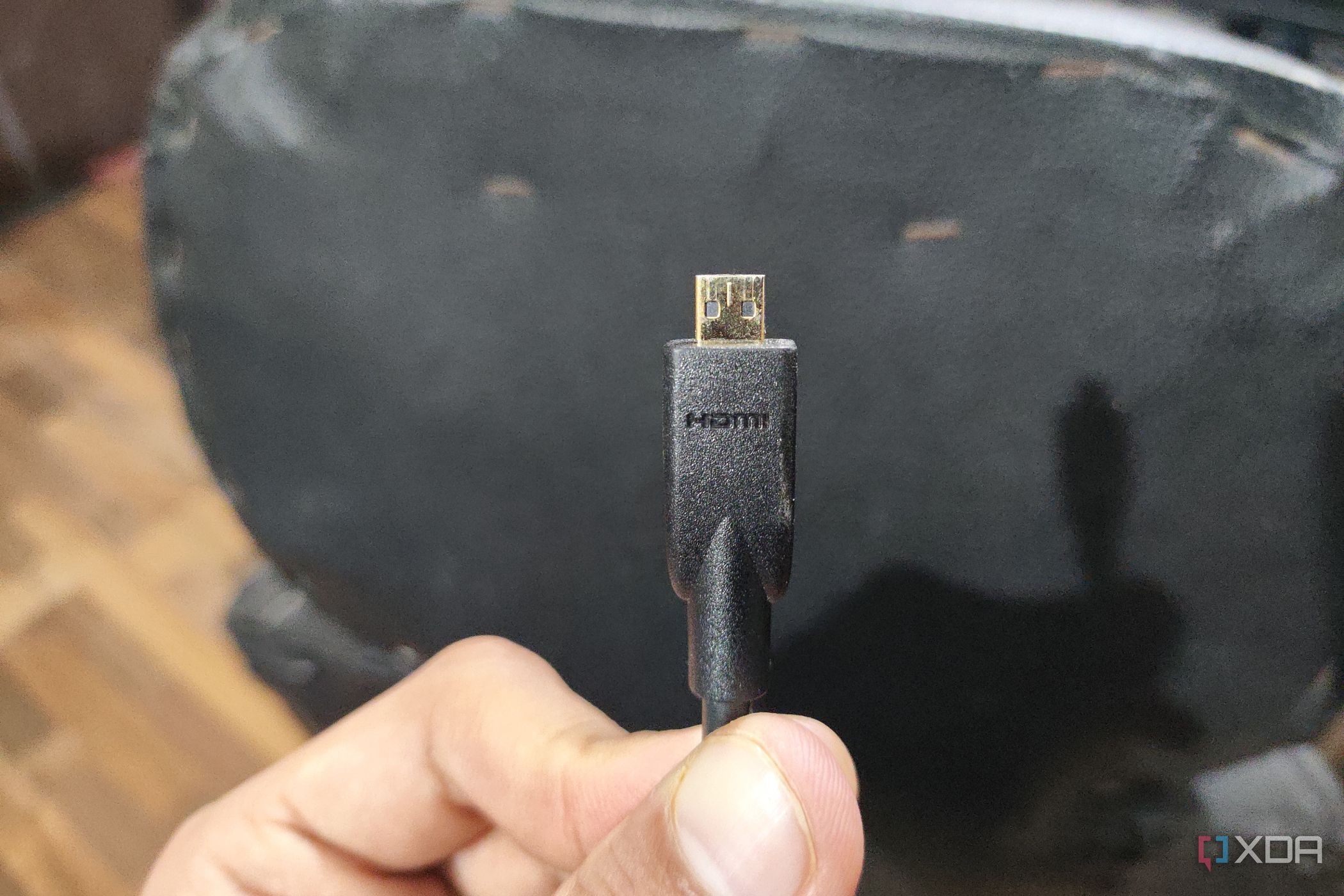 A person holding a micro-HDMI cable