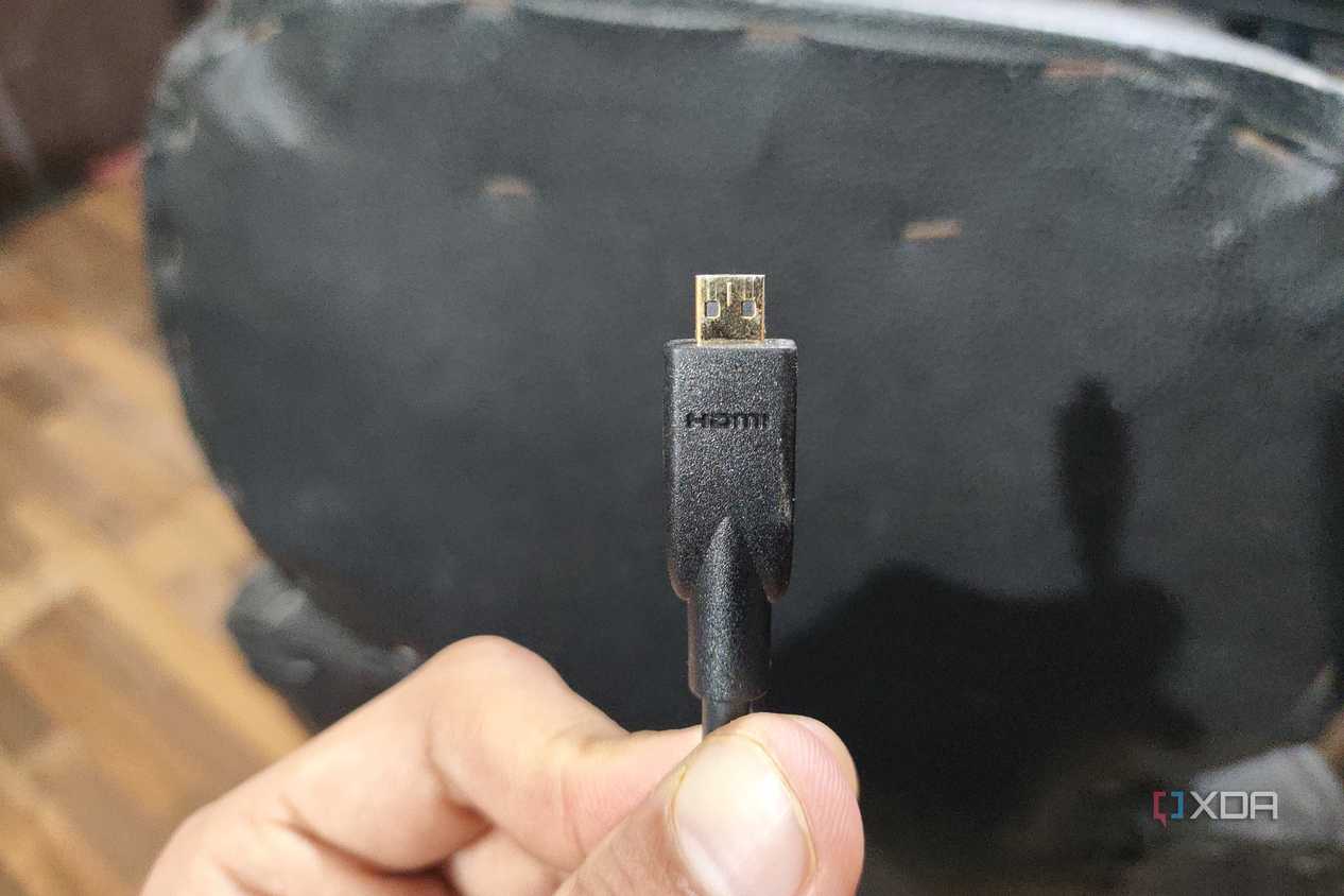 A person holding a micro-HDMI cable