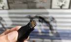 A person holding a mini HDMI to HDMI adapter