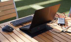 The back view of a mini PC setup on a table outdoors.