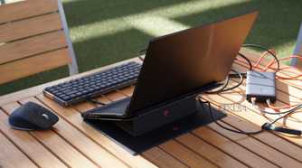 The back view of a mini PC setup on a table outdoors.