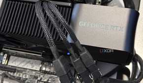 nvidia geforce rtx 4080 super graphics card installed in a motherboard showing three power cables going into its power adapter