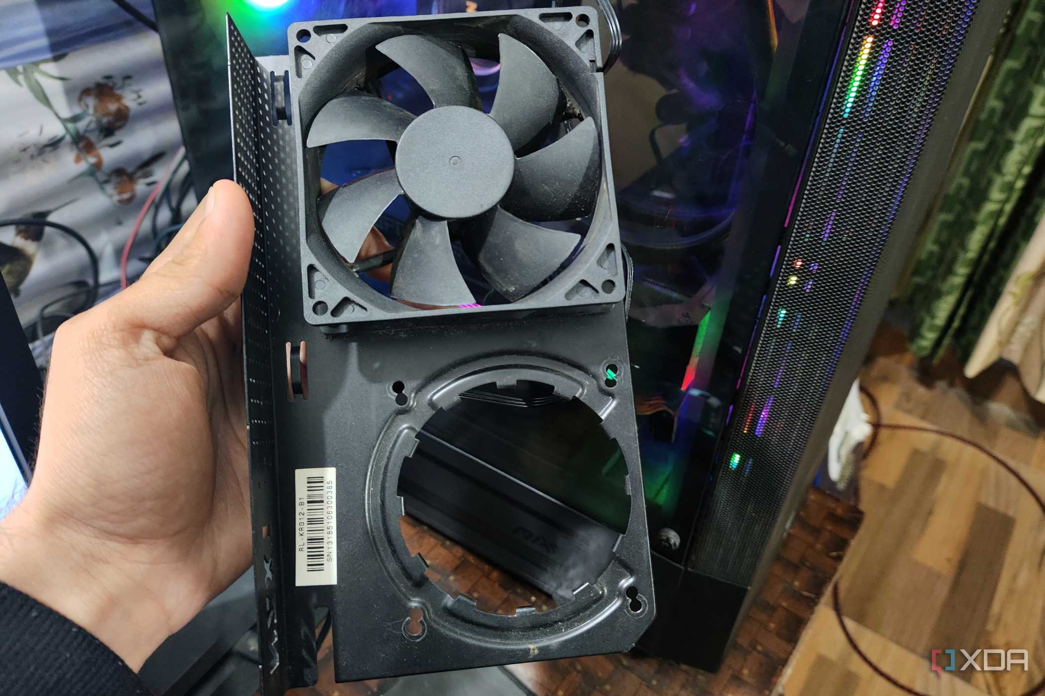 A person holding an NZXT Kraken G12 in front of a PC