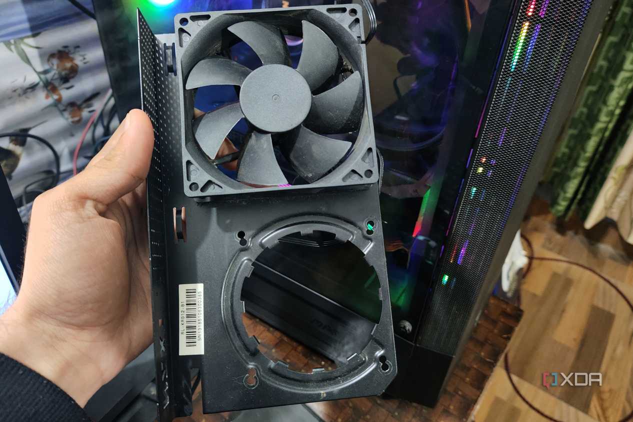 A person holding an NZXT Kraken G12 in front of a PC