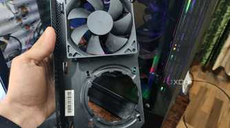 A person holding an NZXT Kraken G12 in front of a PC