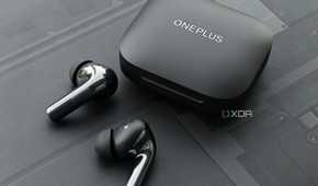 An image showing a pair of OnePlus Buds 3 earbuds sitting next to its charging case.