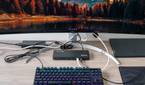 A desk setup with a monitor, keyboard, and laptop, with the Plugable TBT4-UD5 in the center