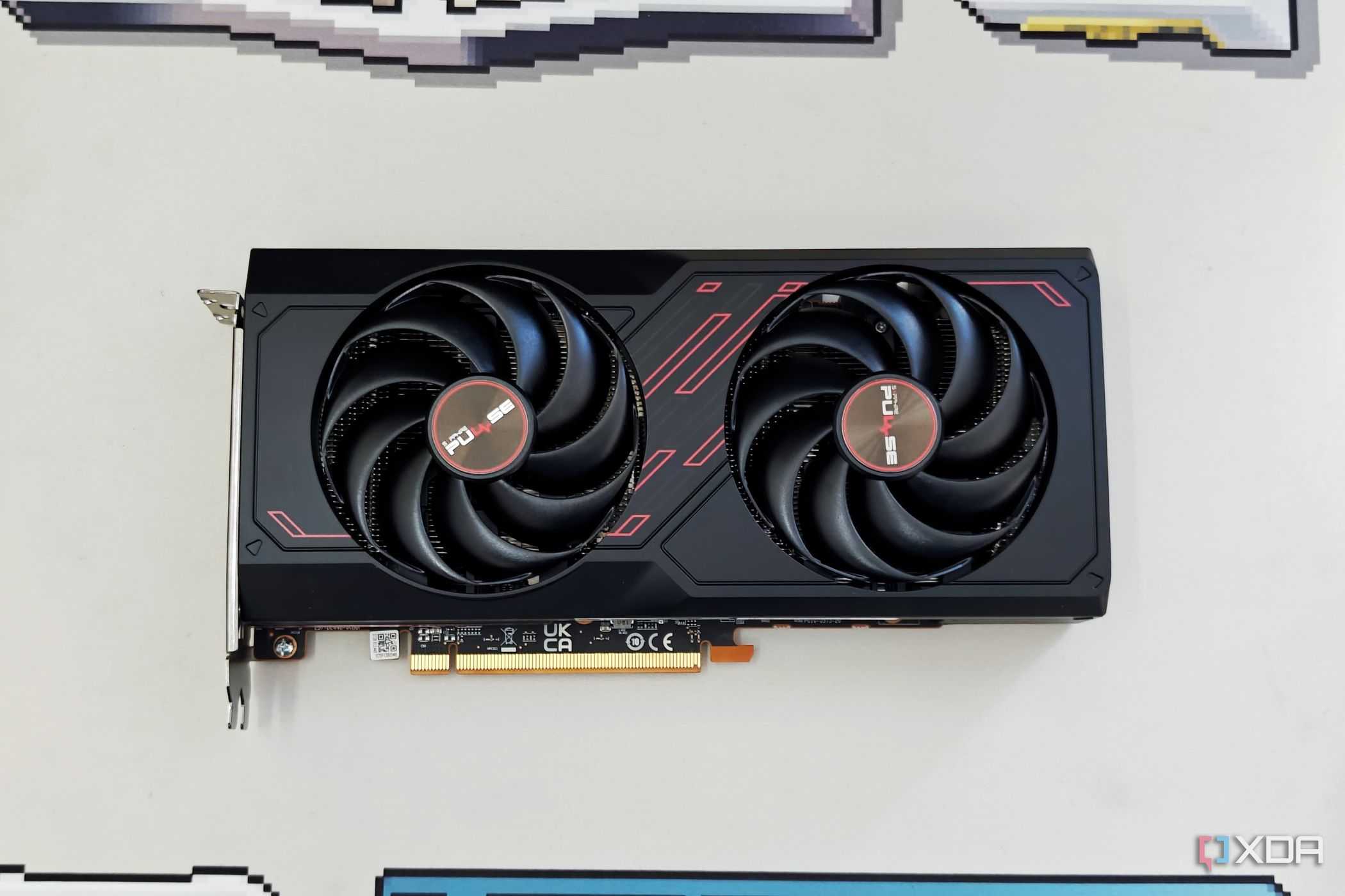 An image showing the Sapphire Radeon RX 7600 Pulse OC GPU kept on a beige deskmat.