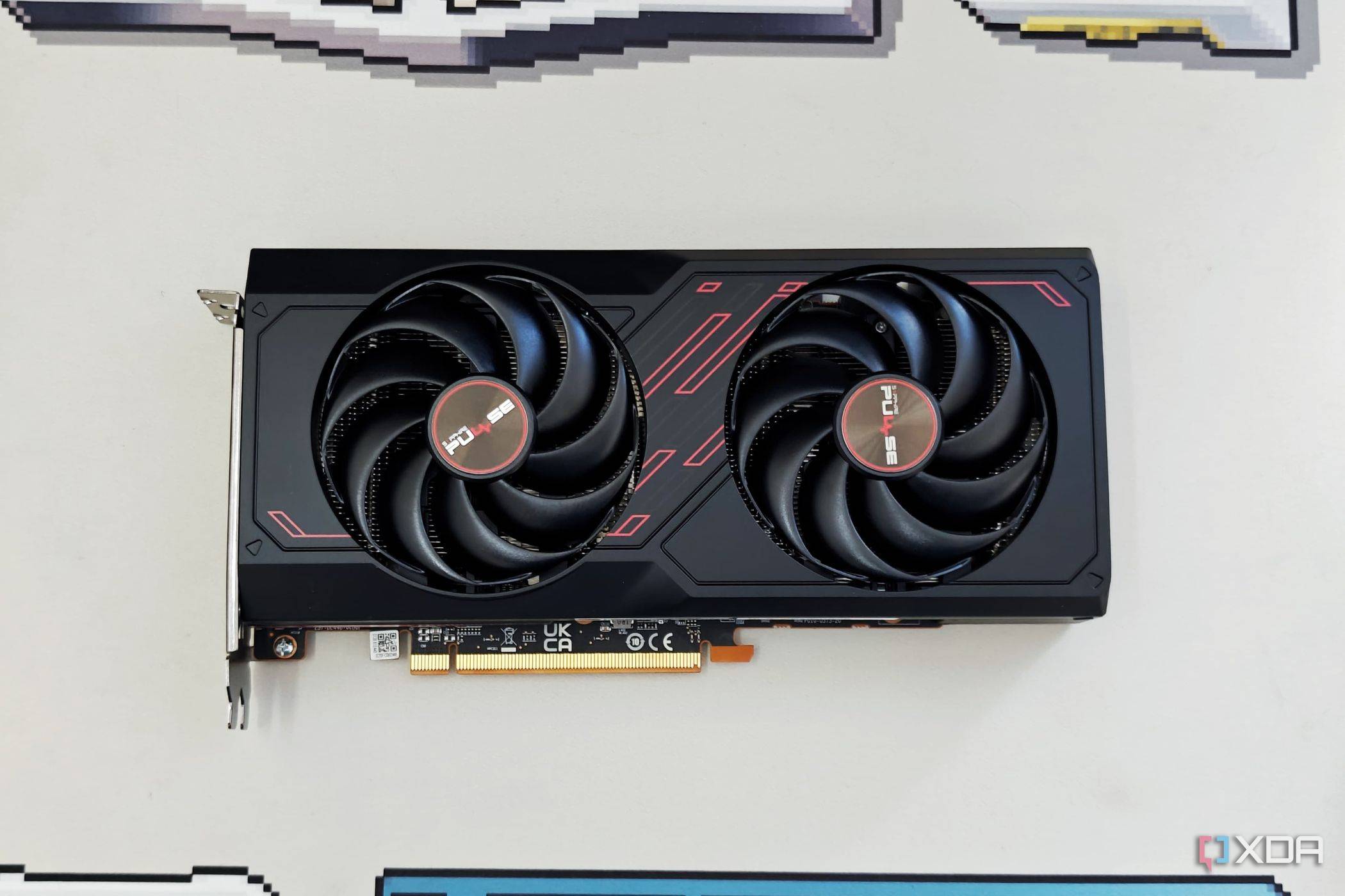 An image showing the Sapphire Radeon RX 7600 Pulse OC GPU kept on a beige deskmat.