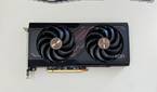 An image showing the Sapphire Radeon RX 7600 Pulse OC GPU kept on a beige deskmat.