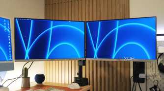 Two Samsung monitors mounted to a desk with the StarTech Dual Monitor Arm.