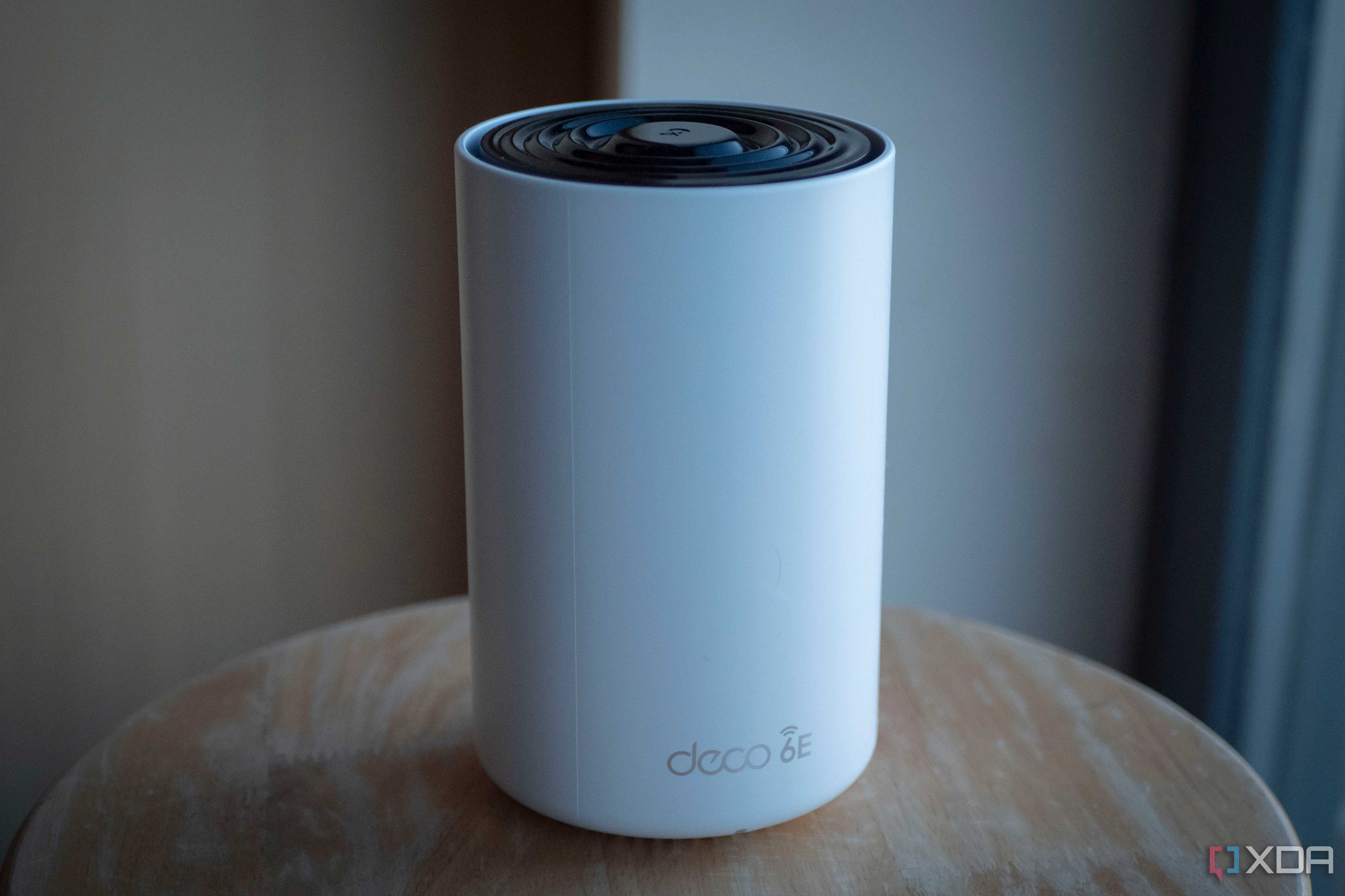 TP-Link Deco XE75 on a table, showing the deco 6e logo on the front