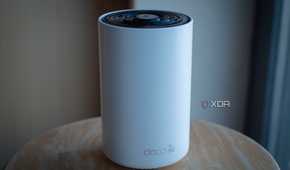 TP-Link Deco XE75 on a table, showing the deco 6e logo on the front