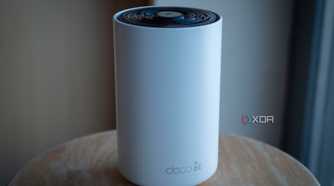 TP-Link Deco XE75 on a table, showing the deco 6e logo on the front