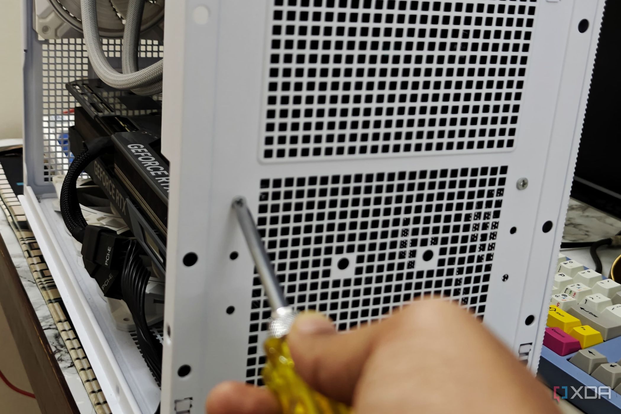 An image showing a person undoing the screws holding the PSU on the case.