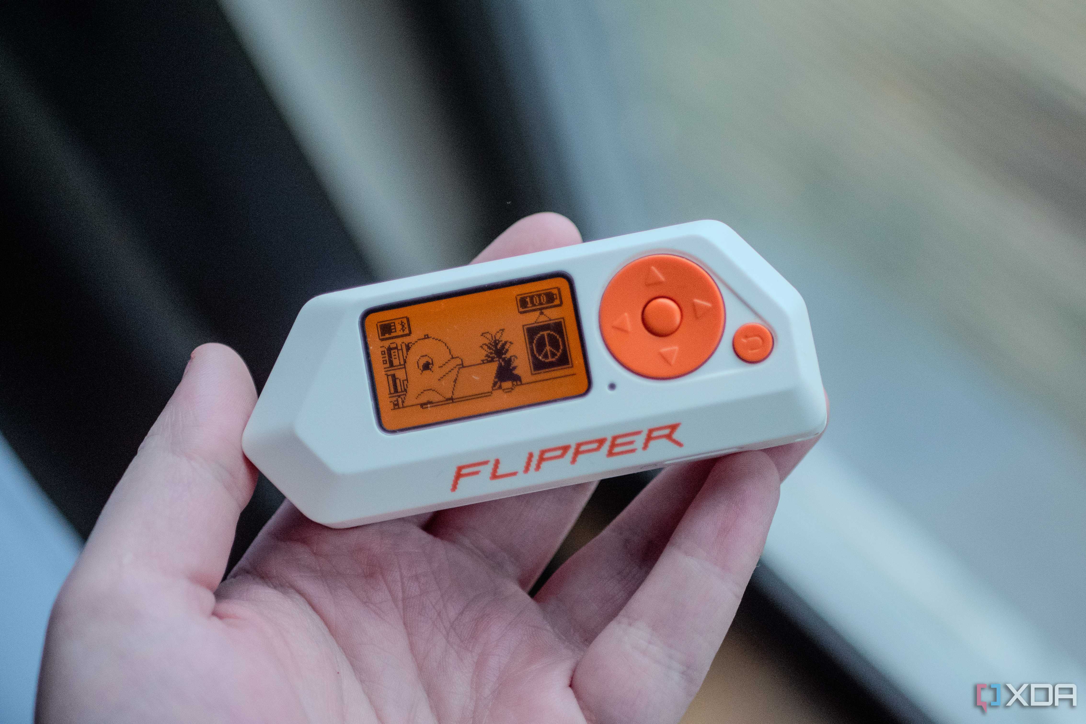 Flipper Zero in ahnd, showing home screen