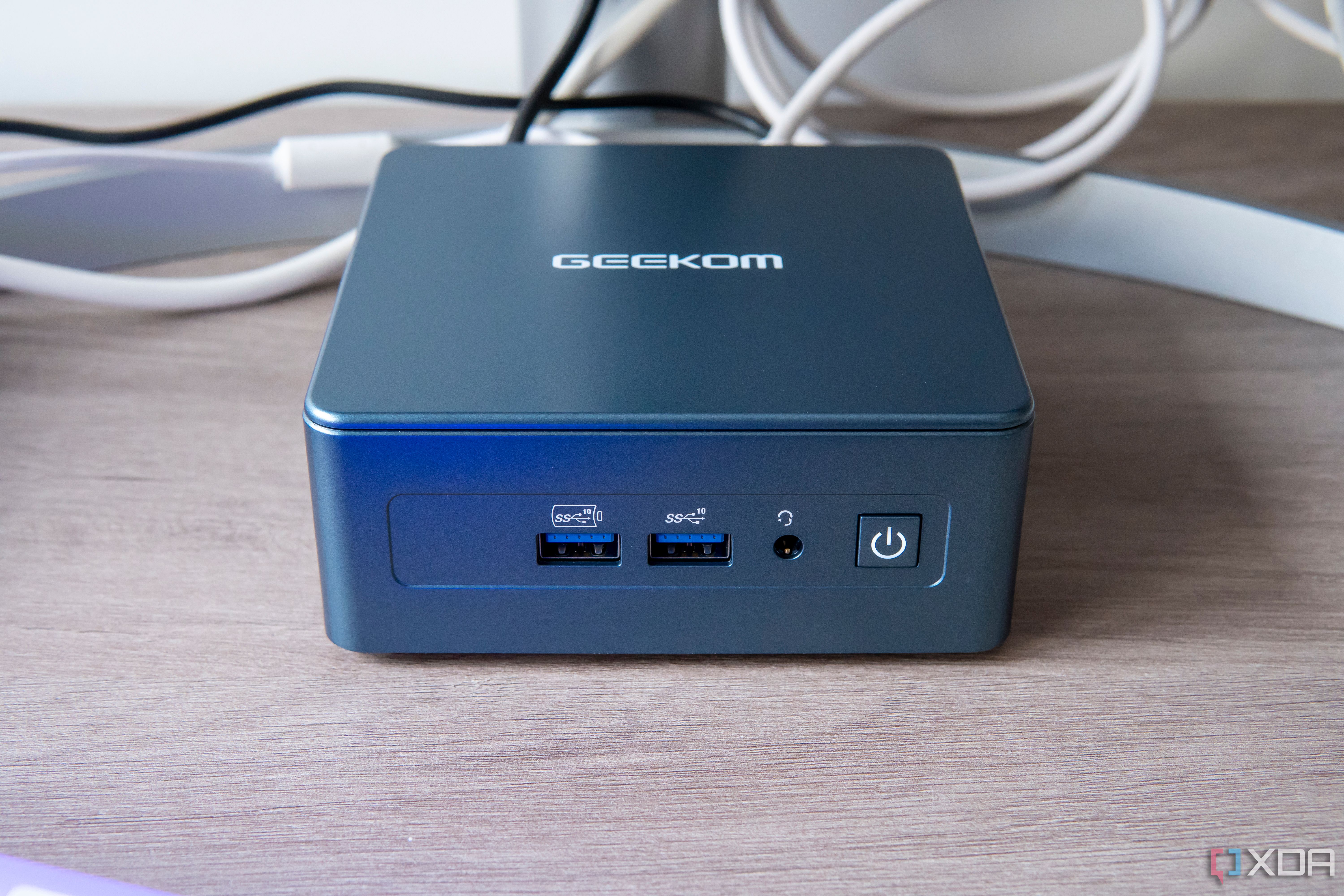 Front view of the Geekom Mini IT13 in front of a monitor