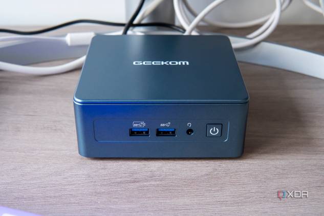 Front view of the Geekom Mini IT13 in front of a monitor