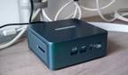 Angled front view of the Geekom Mini IT13 in front of a monitor