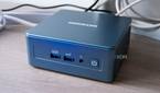 Angled front view of the Geekom Mini IT13 in front of a monitor