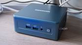 Angled front view of the Geekom Mini IT13 in front of a monitor