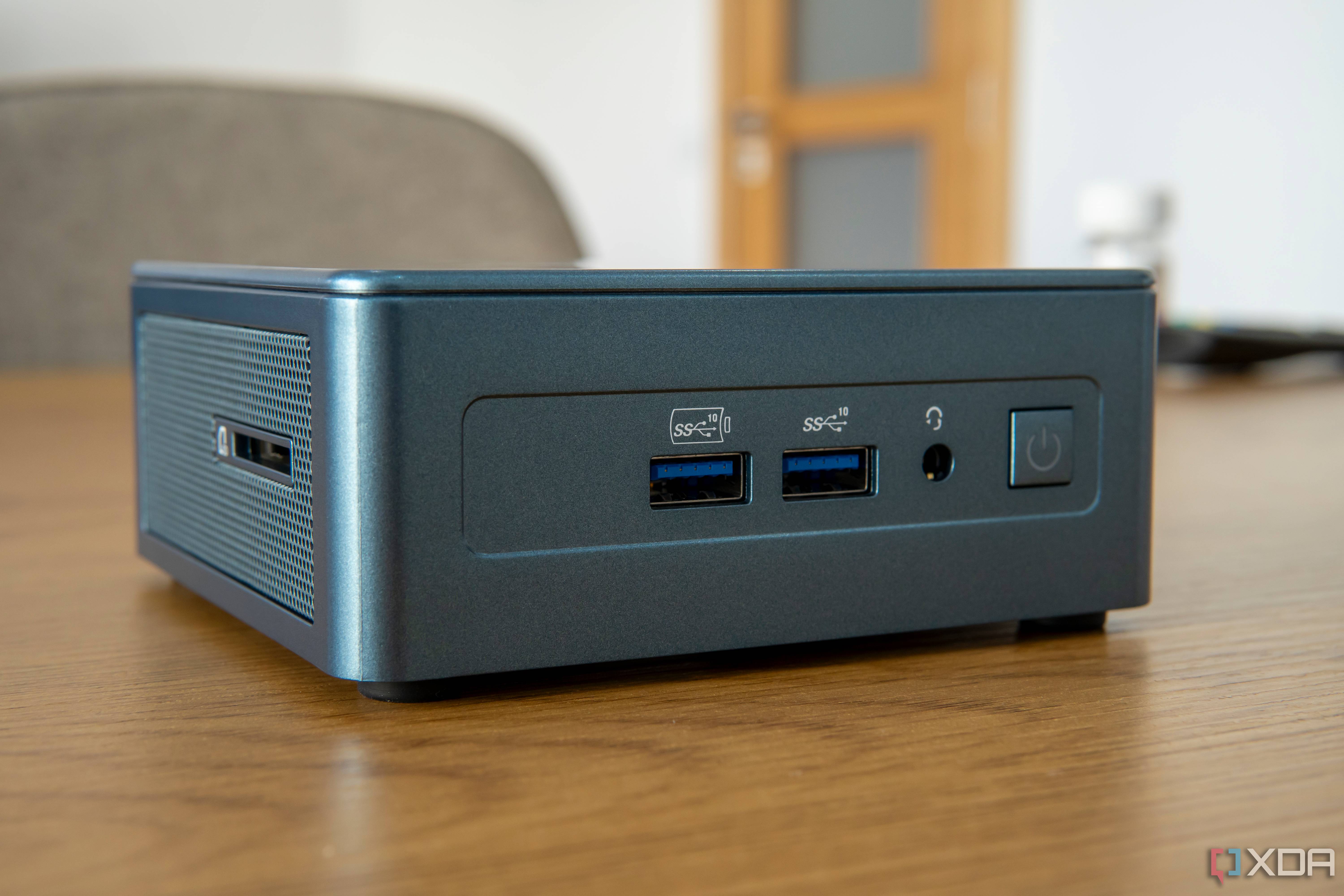 Angled front view of the Geekom Mini IT13 on a wooden table