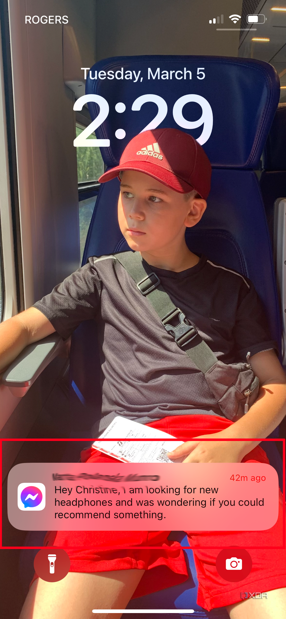 An iPhone lock screen with a young boy and a Messenger message notification visible.