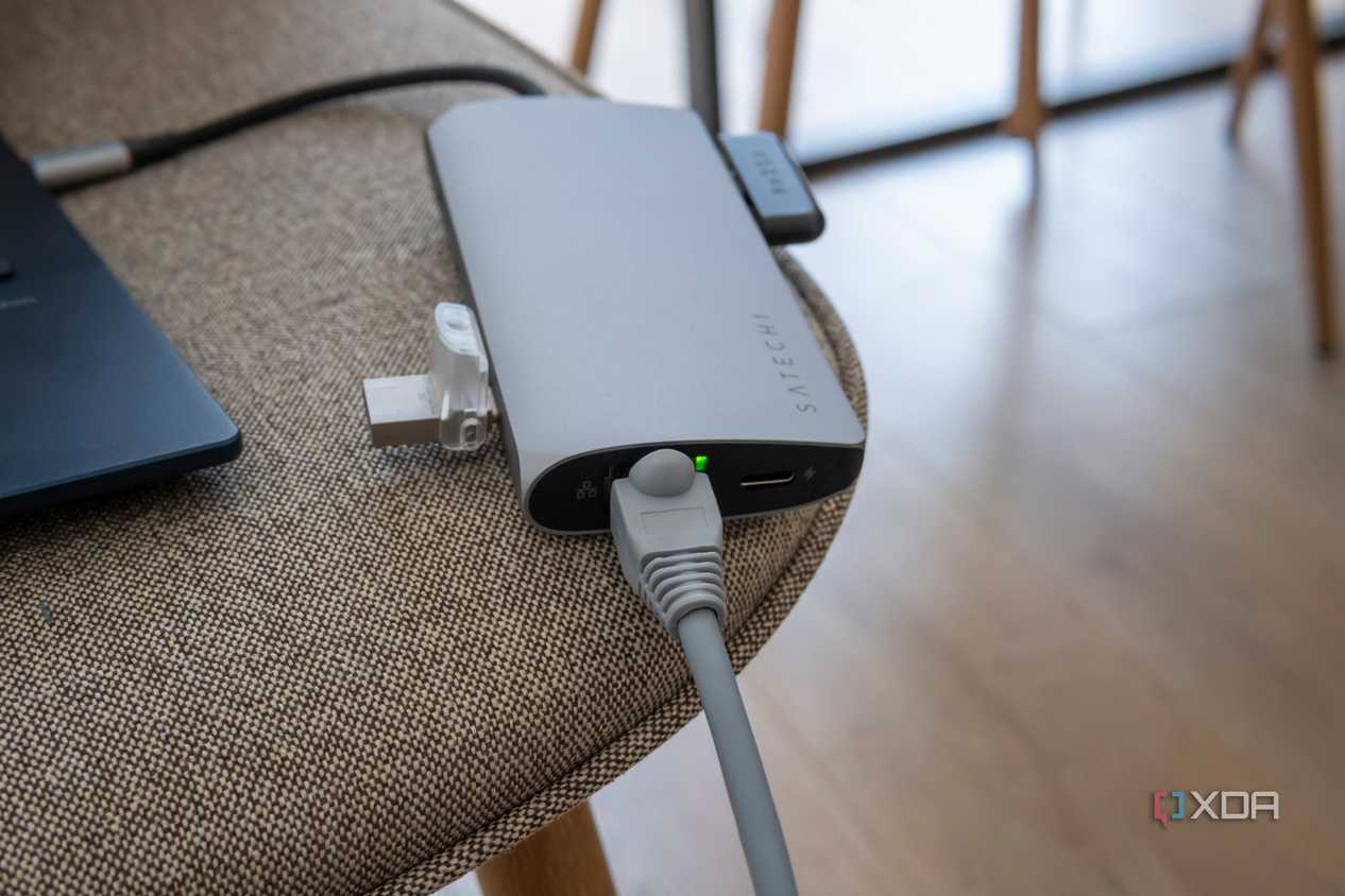Satechi Multiport Adapter 8K with Ethernet V3 with an Ethernet cable and indicator light turned on