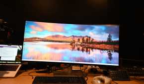 Dell UltraSharp 40 Curved Thunderbolt Hub Monitor with wallpaper of rising sun in a blue sky with mountains in the background