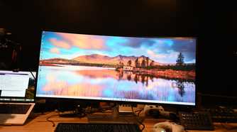 Dell UltraSharp 40 Curved Thunderbolt Hub Monitor with wallpaper of rising sun in a blue sky with mountains in the background