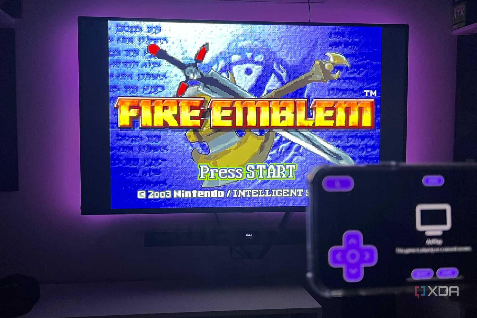 A picture of an iPhone 11 streaming the Fire Emblem game to a TV through AirPlay while using the Delta app.
