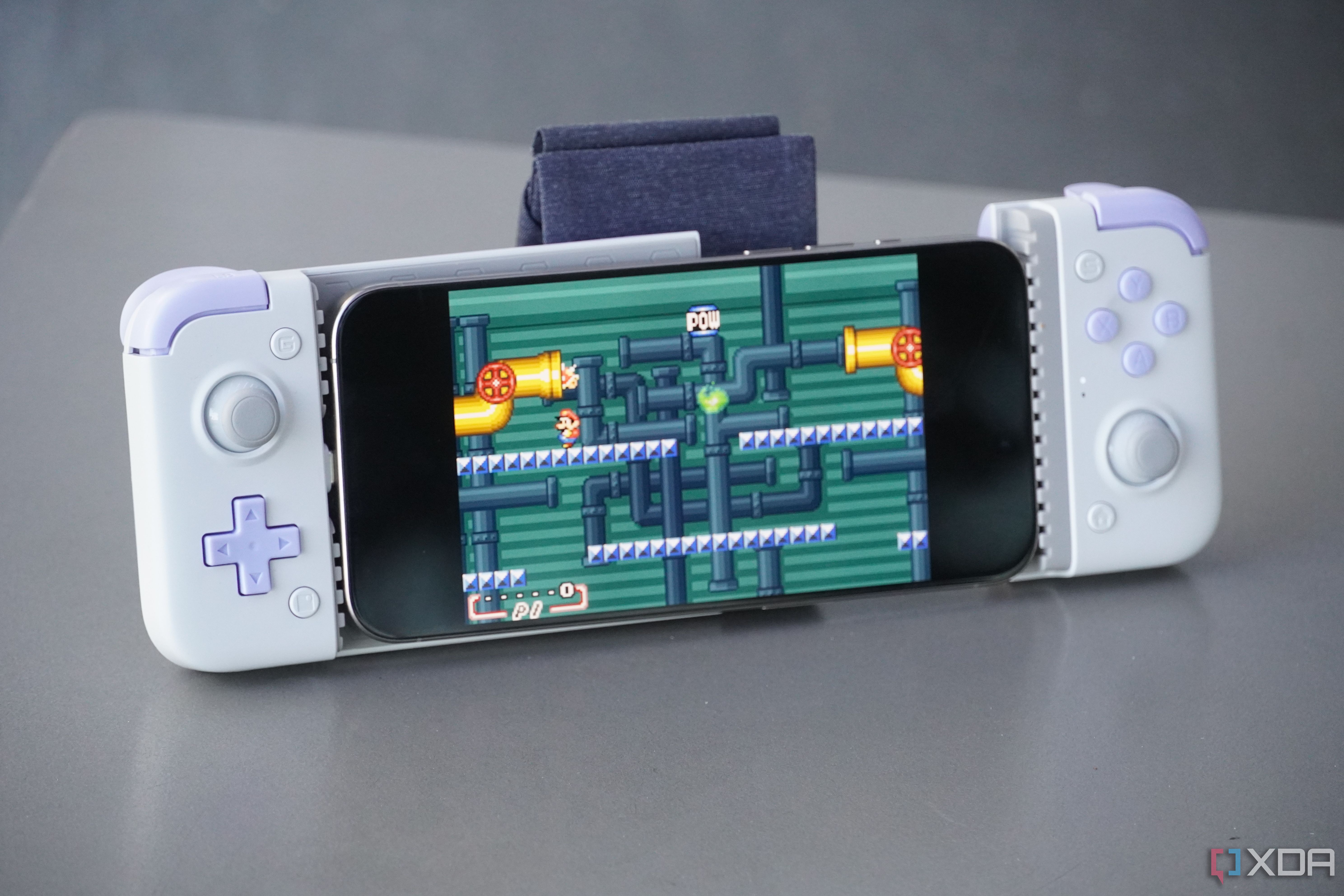 An iPhone connected to a bulky external game controller.