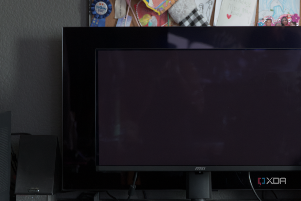 The MSI MAG 271QPX next to the LG C2 showing the difference in black levels