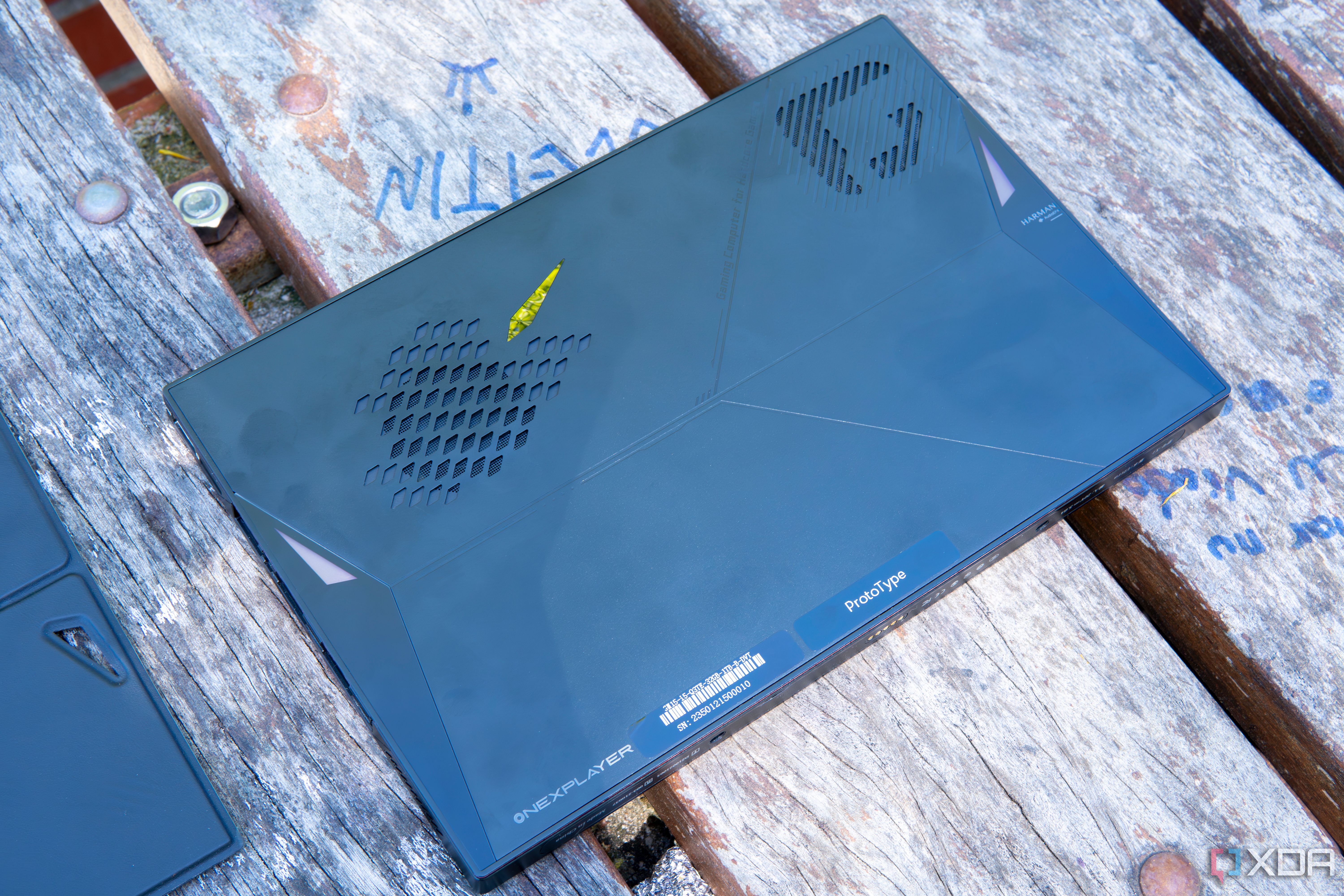 A One XPlayer face down on a wooden table with the back plate removed