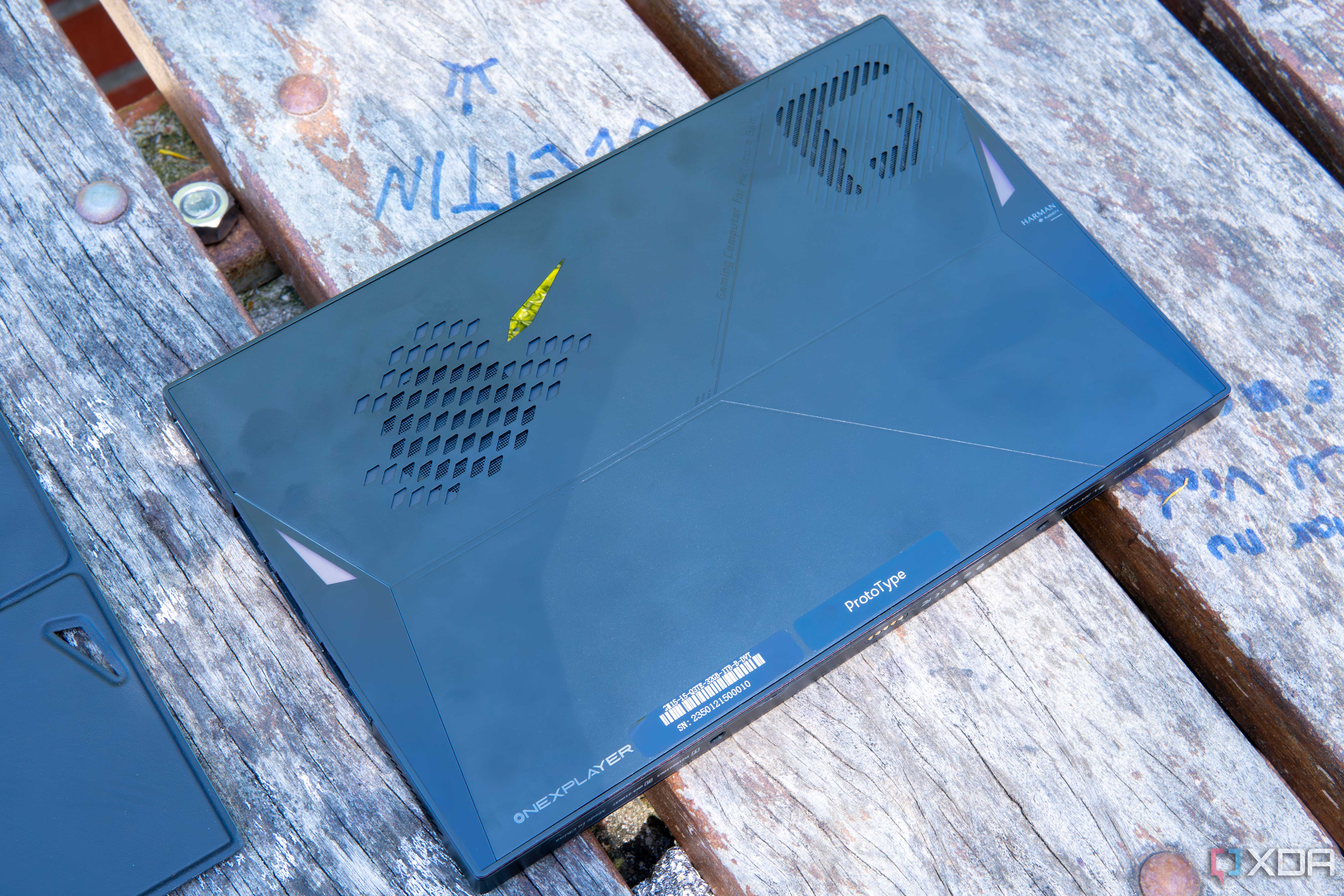 A One XPlayer face down on a wooden table with the back plate removed