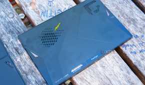 A One XPlayer face down on a wooden table with the back plate removed