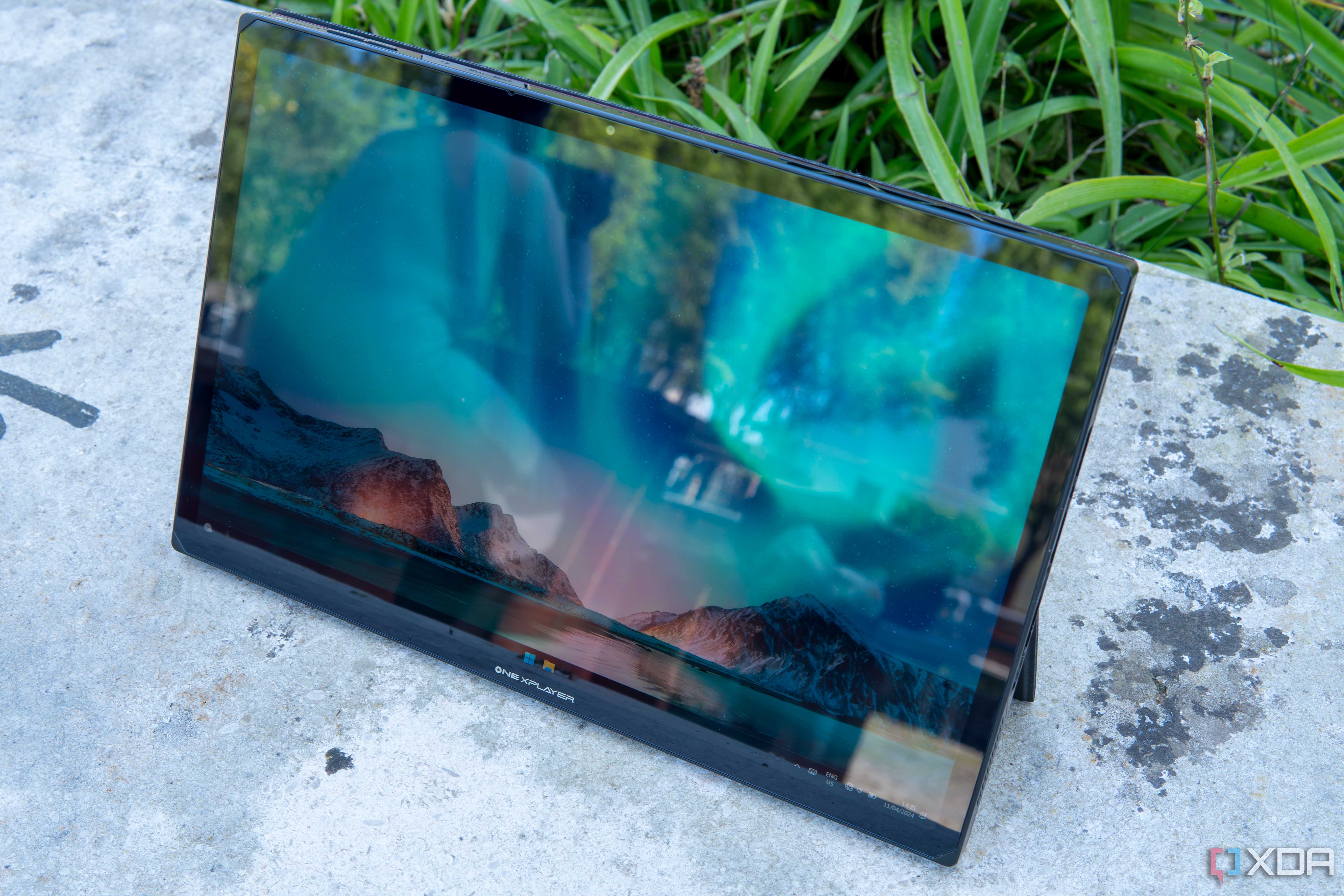 Angled front view of the One XPlayer X1 showing the Windows 11 desktop with controllers detached