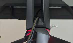 An image showing the tripod stand of the Asus ROG PG27AQDM with cables routed through it.