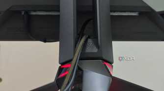 An image showing the tripod stand of the Asus ROG PG27AQDM with cables routed through it.
