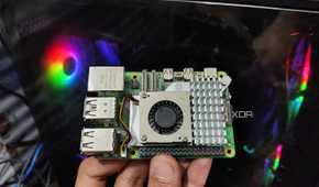 A Raspberry Pi 5 held in front of a PC