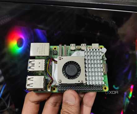 Một Raspberry Pi 5 được cầm trước mặt một chiếc PC