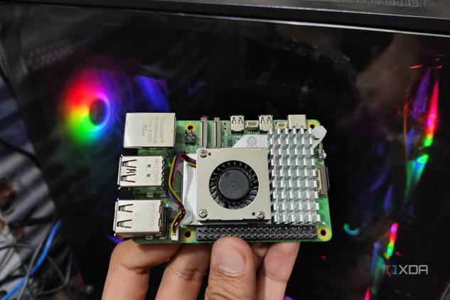 A Raspberry Pi 5 held in front of a PC