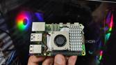 A Raspberry Pi 5 held in front of a PC