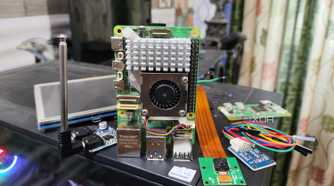 The Raspberry Pi 5 and its accessories lying on top of a PC