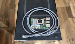 A Raspberry Pi 5 resting on a PC case, with a LAN cable wrapped around it